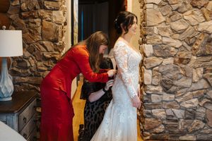 A sequence of photos showing someone getting ready in a stone-walled room wearing a white dress.