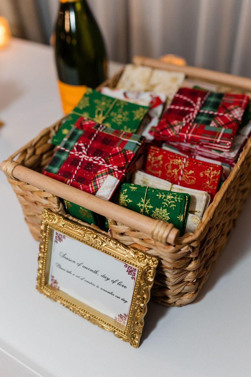 Woven basket filled with red and green holiday tea packets displayed next to an ornate gold picture frame.