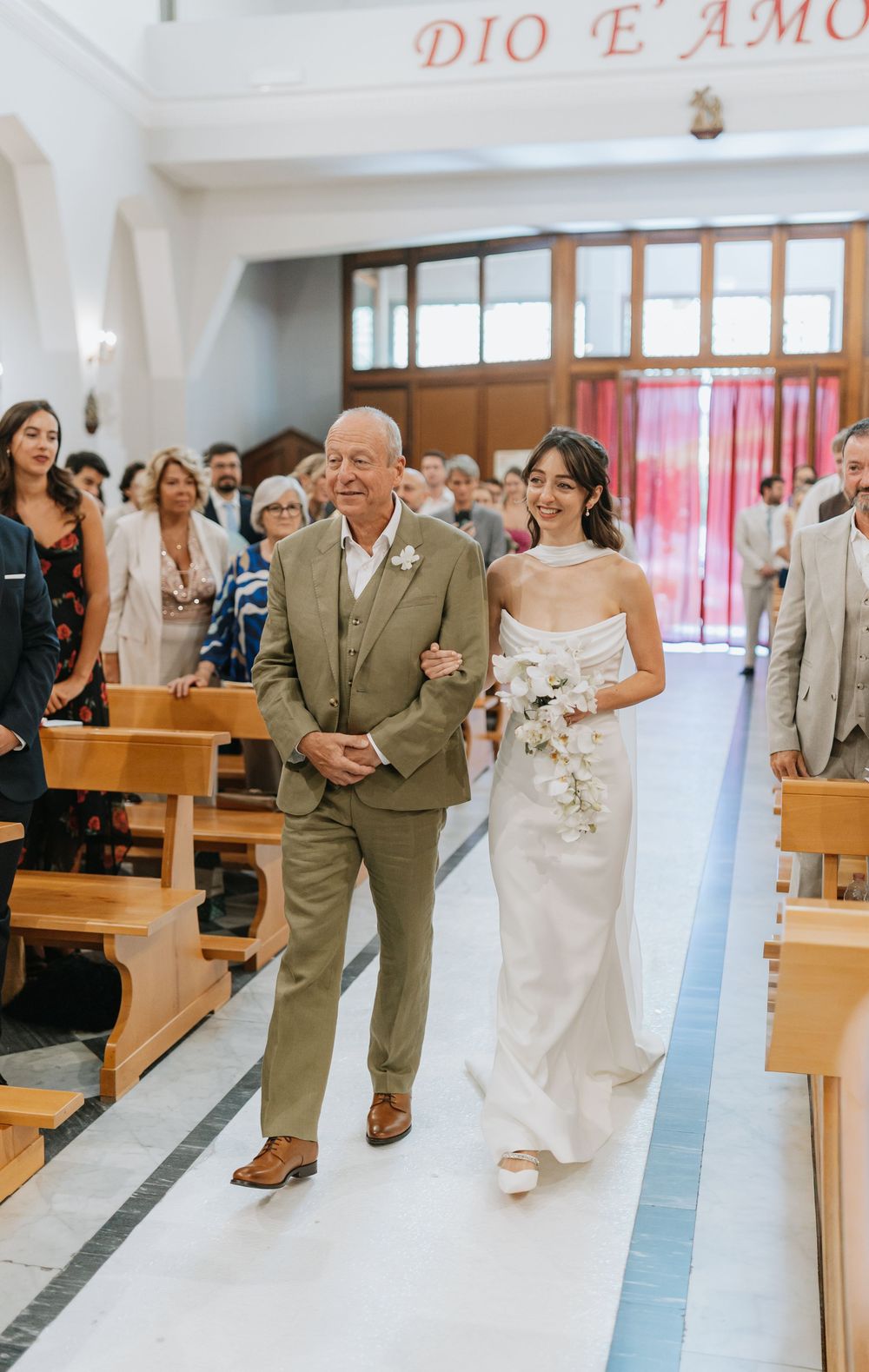 Wedding party members dance and celebrate joyfully down the church aisle during a ceremony recessional.