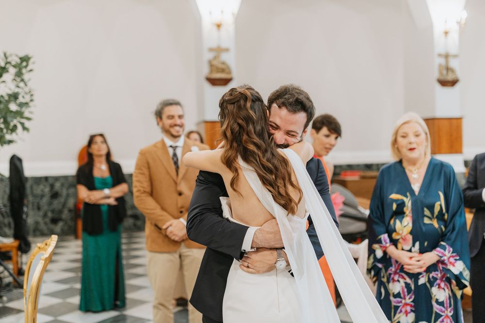 Wedding guests dance and celebrate together on a lively dance floor at an indoor reception venue.
