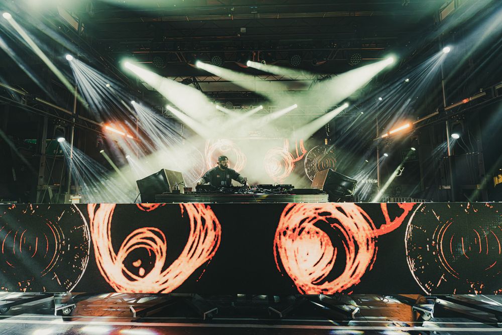 Stage lighting creates dramatic beams and patterns during a live performance.