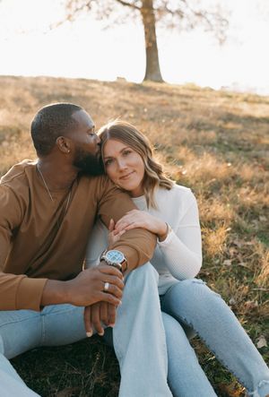 Couple sharing an intimate moment while sitting together in golden sunlight.