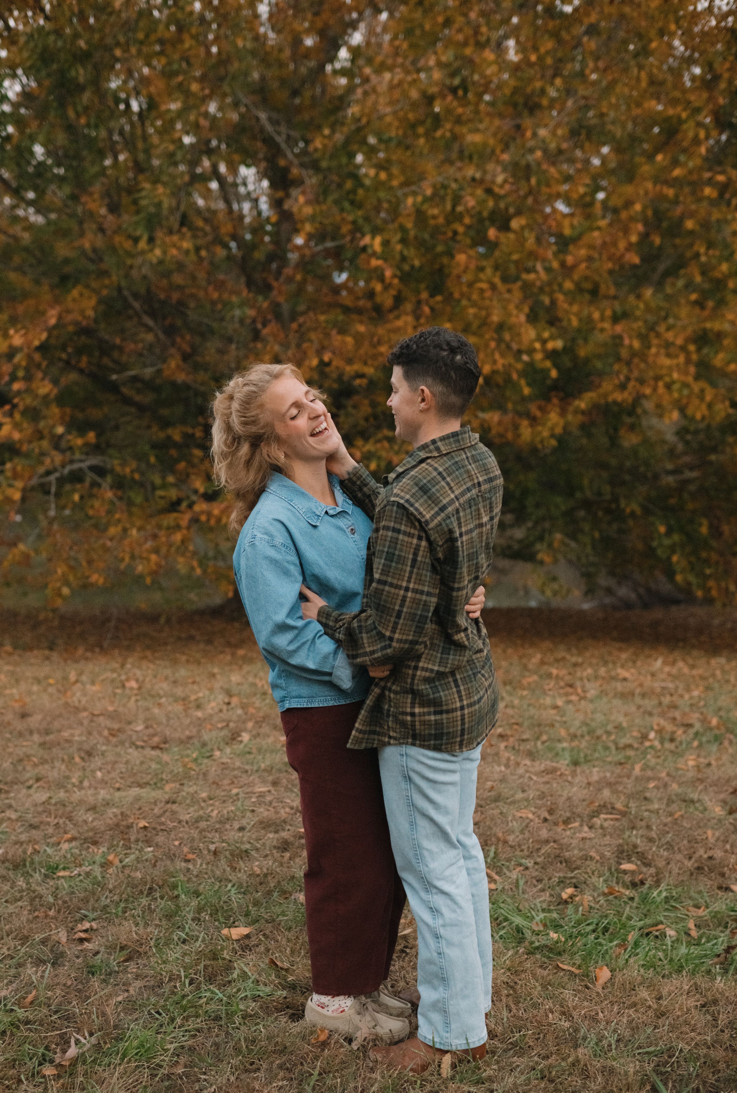 Couple sharing a joyful moment together among autumn trees.