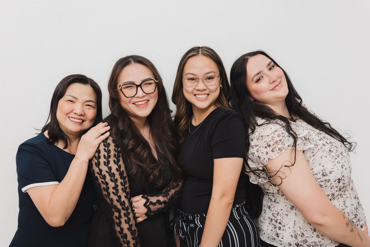 A group of friends in casual black attire pose together for a series of playful photo booth style portraits.