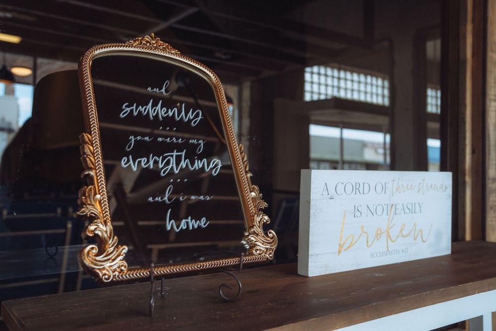 Decorative gold-framed signs with elegant calligraphy displayed at a wedding venue.