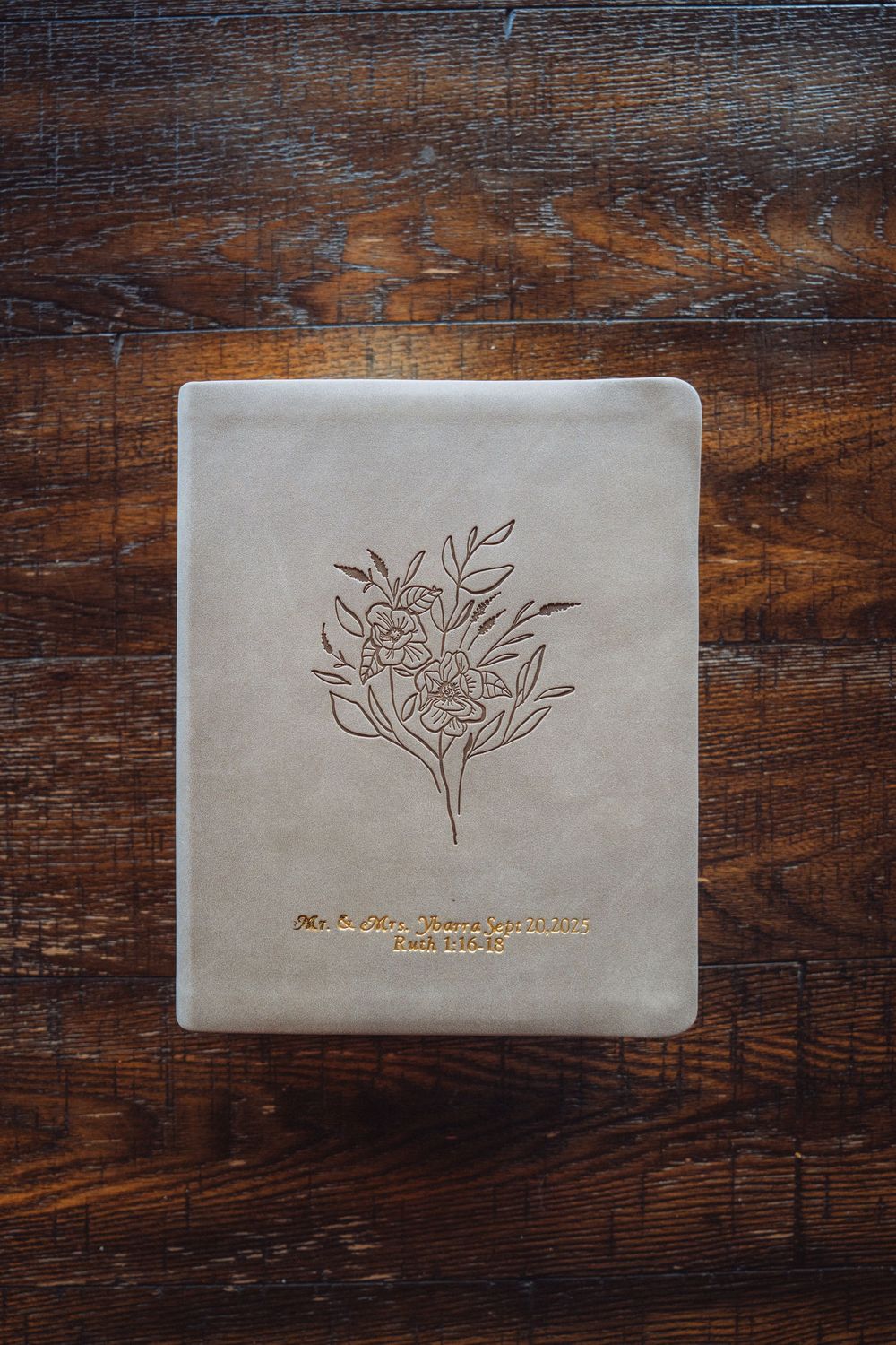 Elegant business card with floral logo design on rustic wooden background.