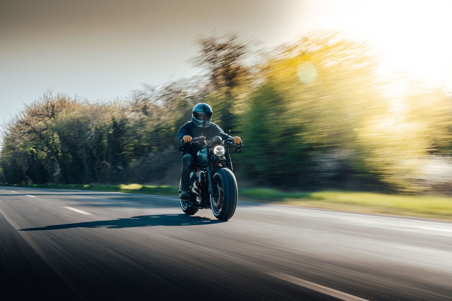 Race car speeds down track with motion blur during golden hour sunset.