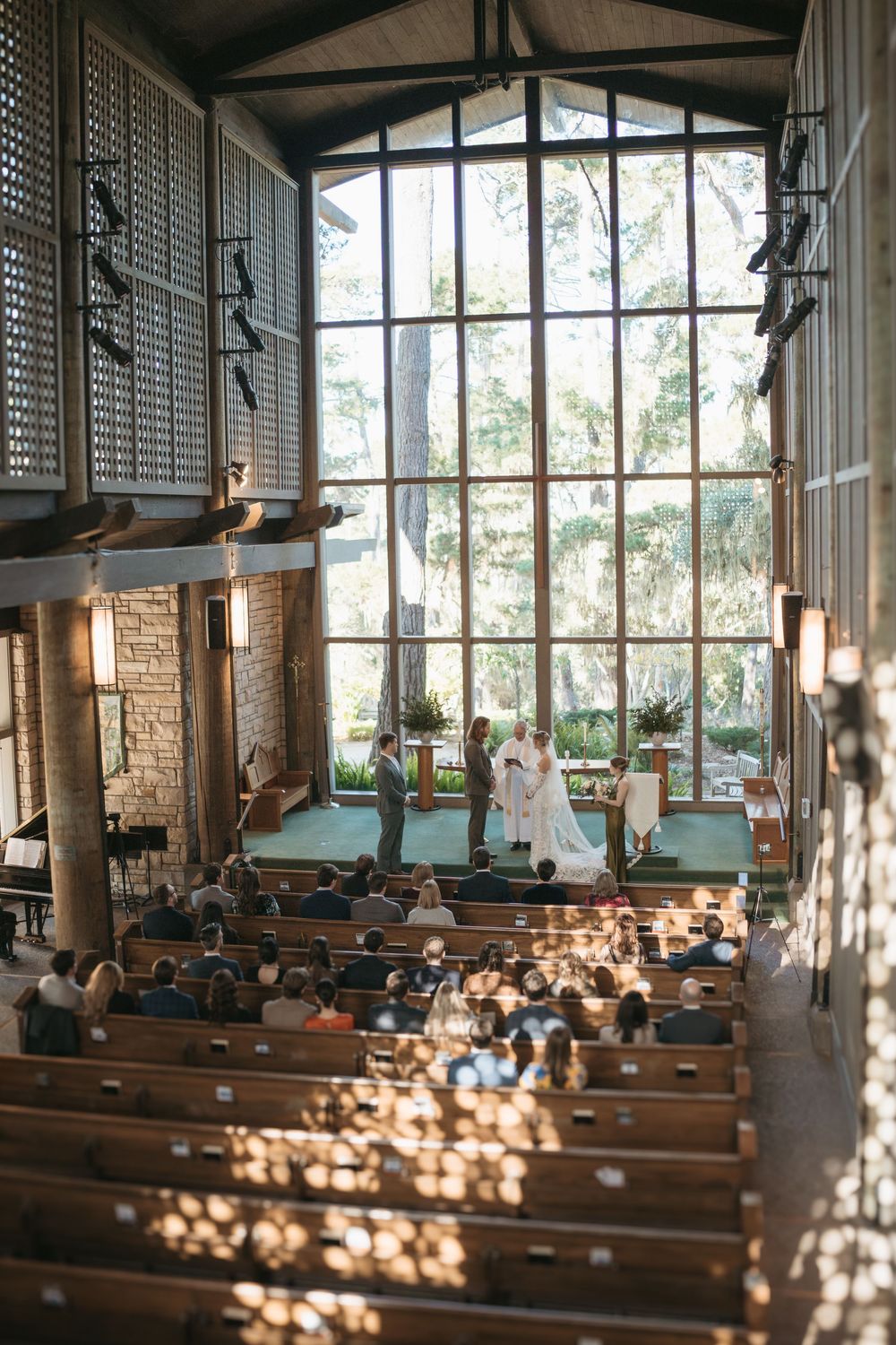 Sunlit church interior with wooden pews and tall windows casting dramatic shadows across the sanctuary.