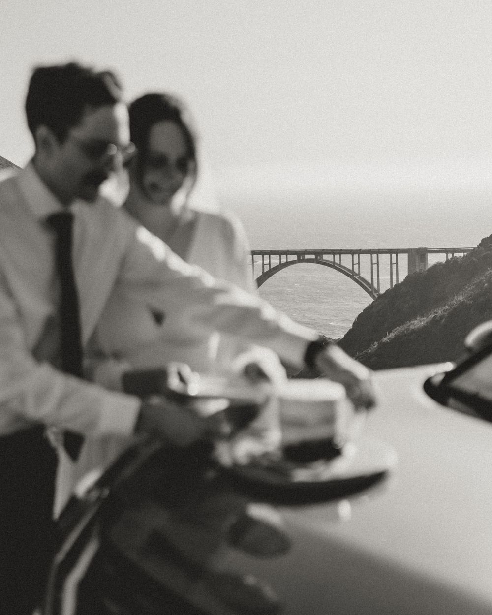 Black and white image of a couple sitting at a table during a reception.