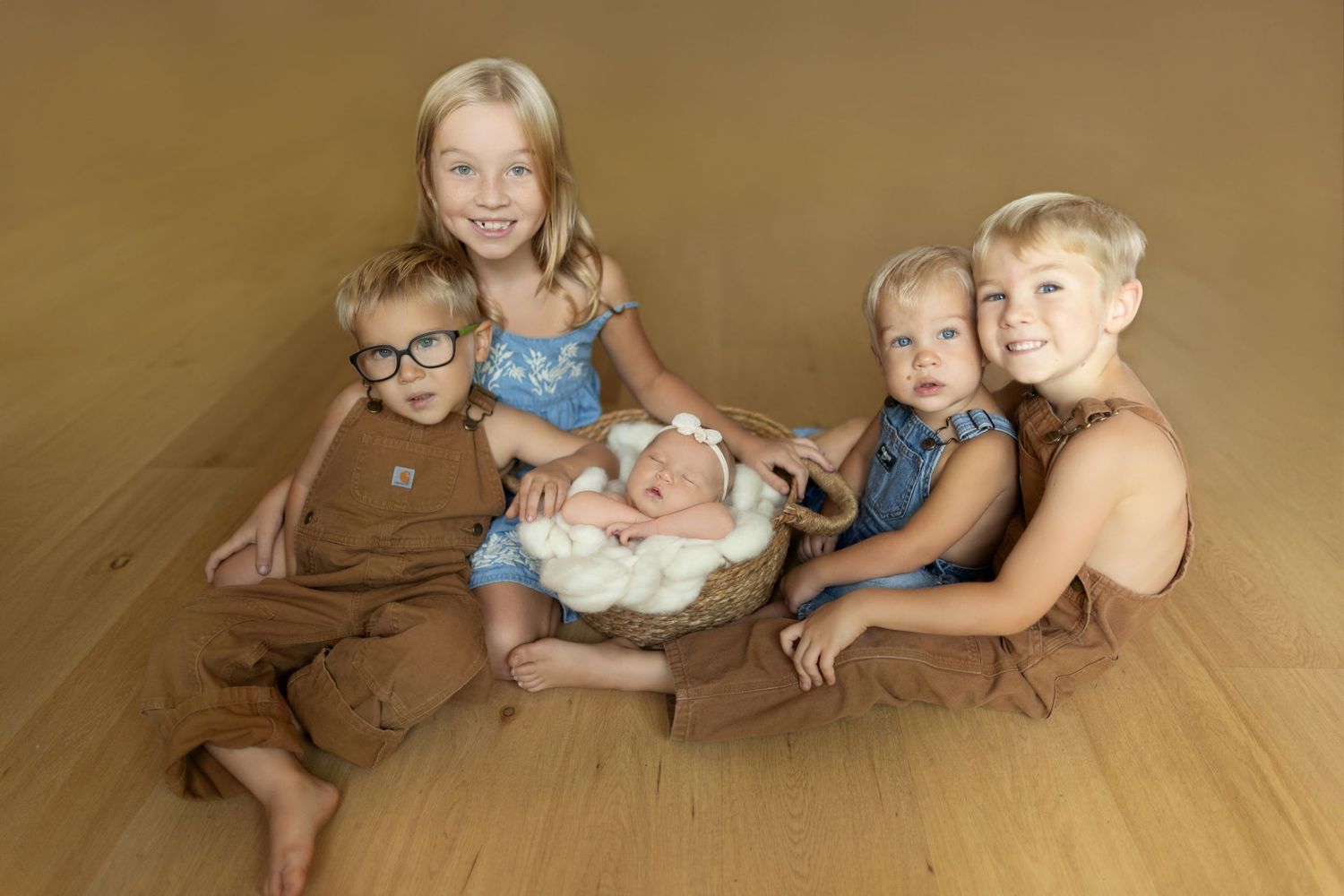 Children laying on a beige carpet in various playful poses shown in a sequence of connected photos.