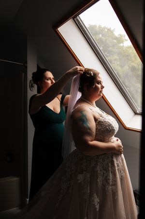 A bride in a white lace gown stands by a window in a series of romantic silhouetted poses.