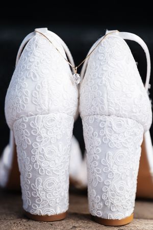White ceramic mugs with delicate swirled lace patterns shown in a series of close-up views against a dark background.