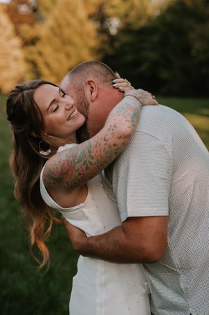 A romantic couple shares intimate moments during a golden hour outdoor photo session in nature.