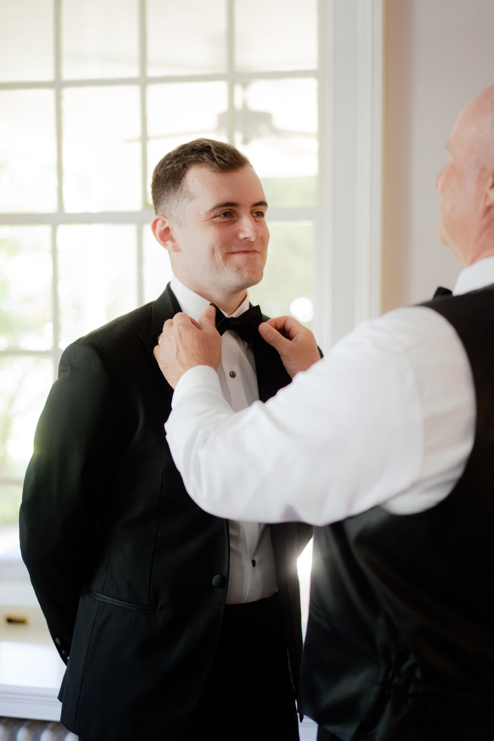 A series of photos showing emotional moments between two people in formal black and white attire at an indoor event.