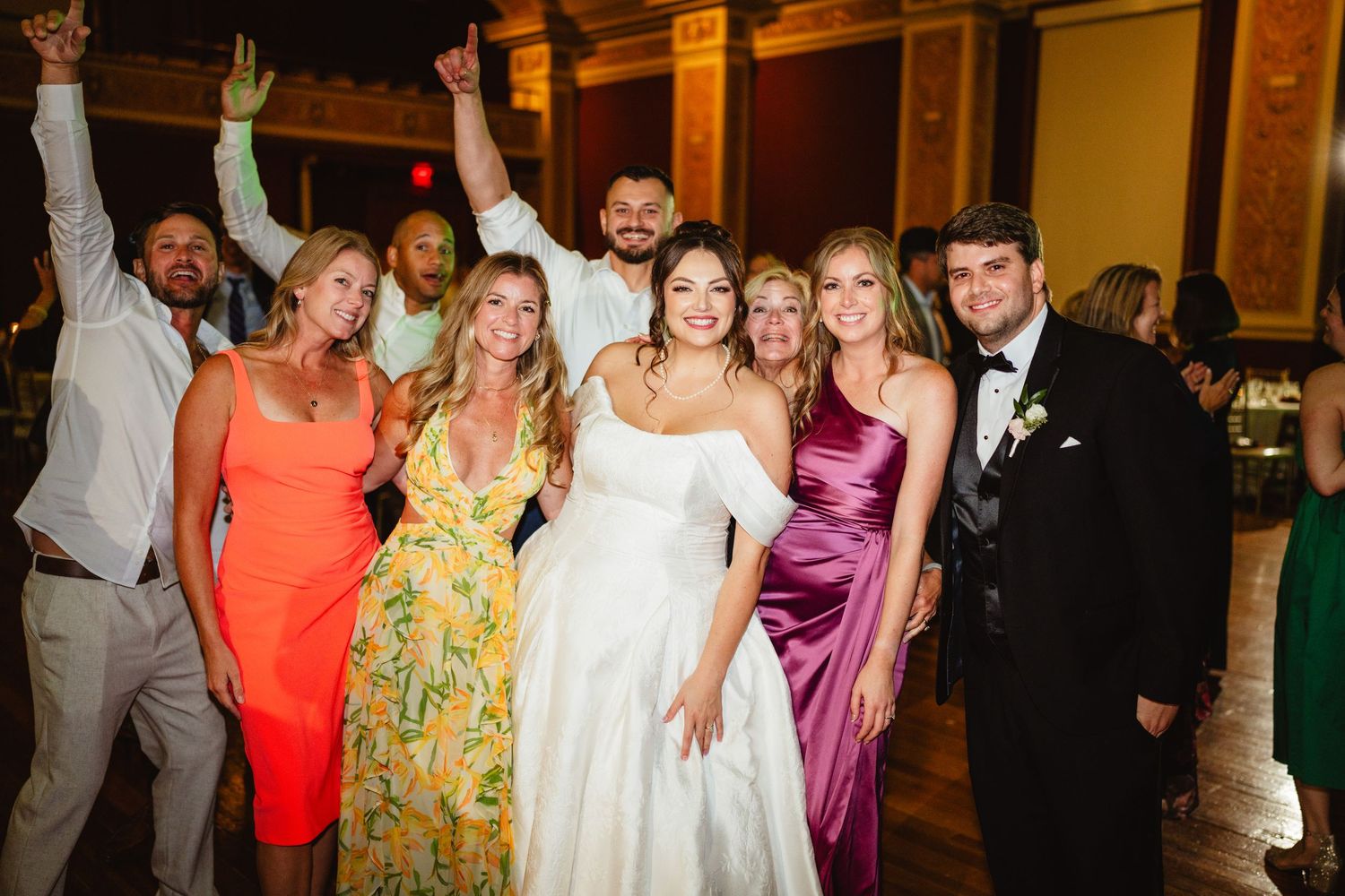 People dancing and celebrating together at an evening event in formal attire.