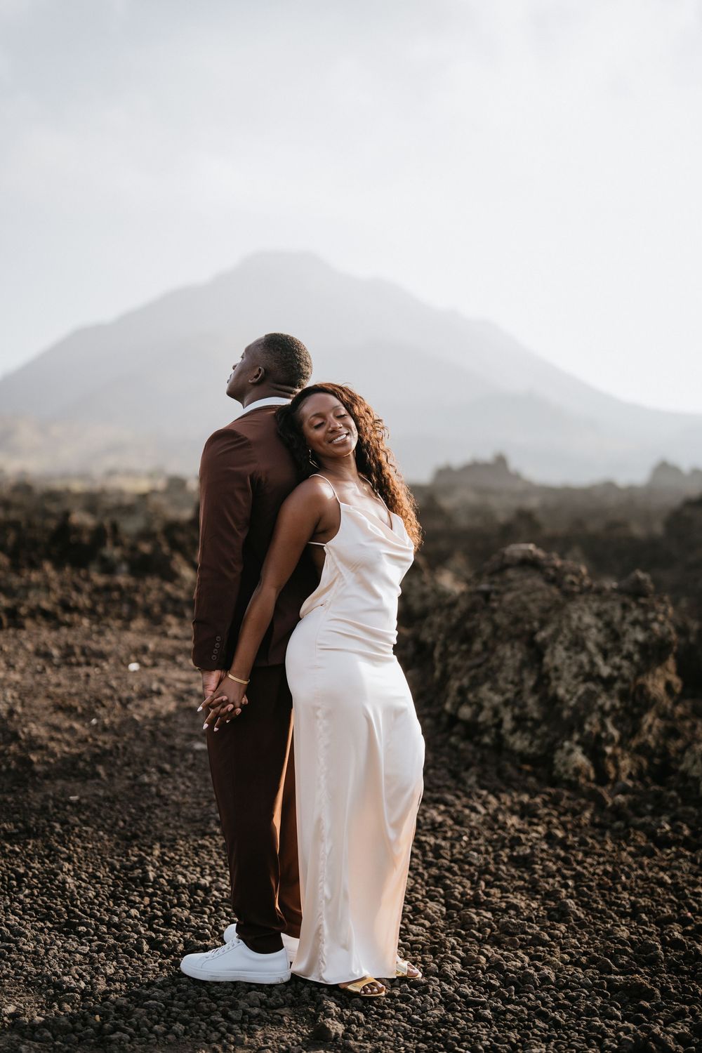 Intimate couples photography on rocky volcanic landscape during golden hour.