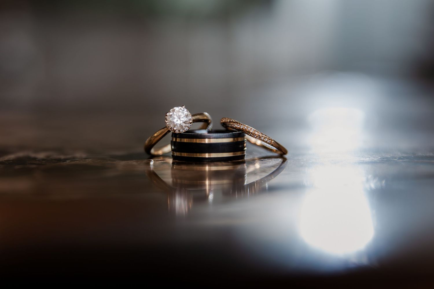 Artistic macro shot of wedding rings with dramatic lighting and bokeh effects at Hauser Hall in Kitchener, Ontario.