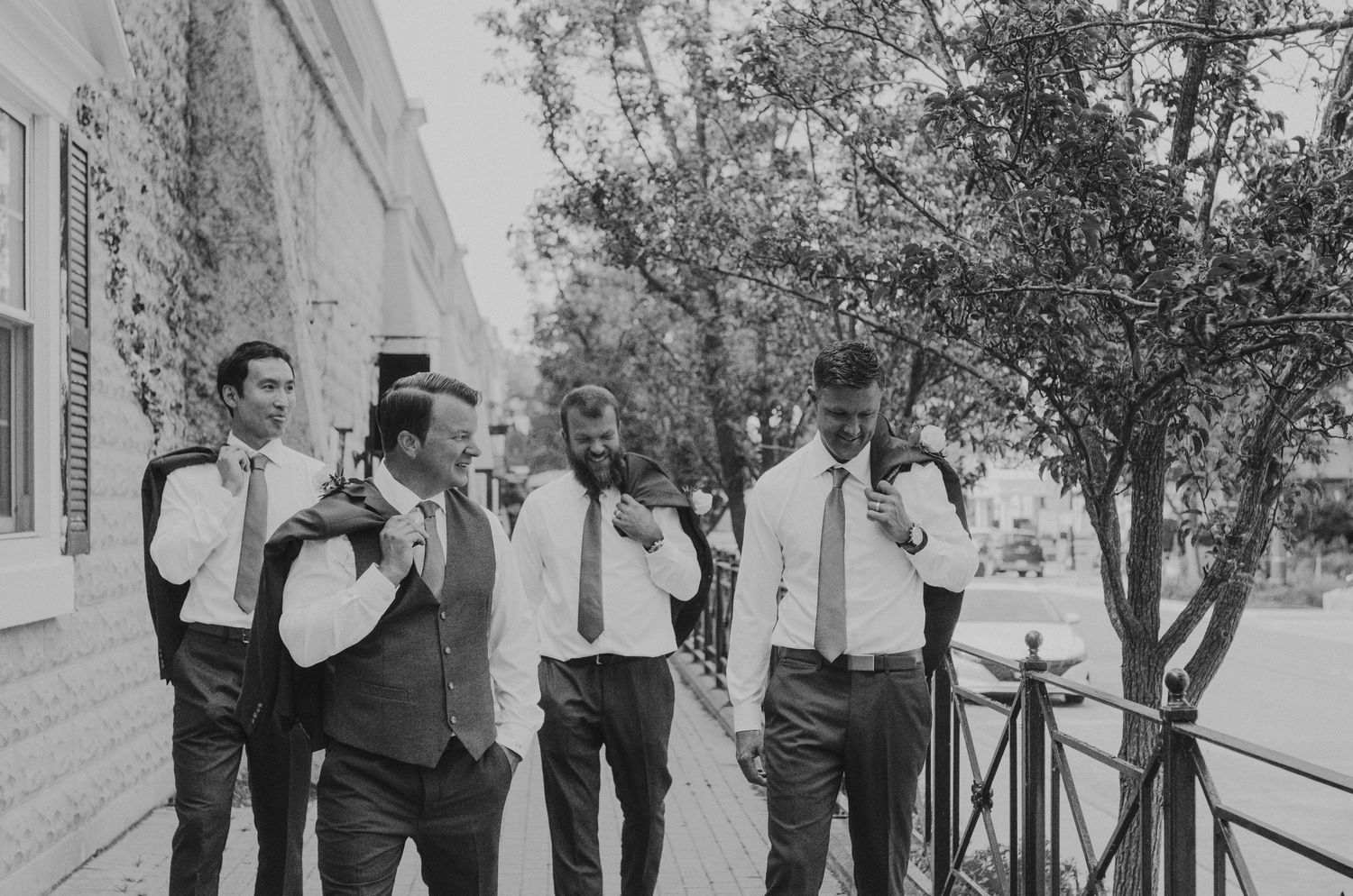 Black and white wedding party portraits outdoors with natural lighting and trees in background.