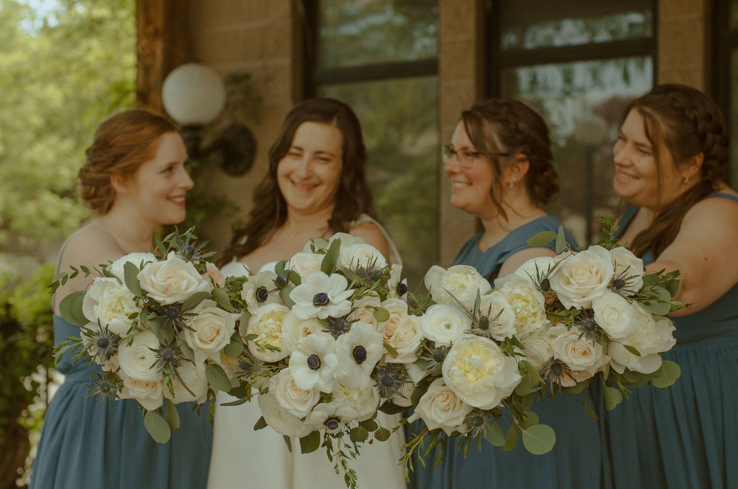 A row of elegant white and cream wedding bouquets with delicate greenery.