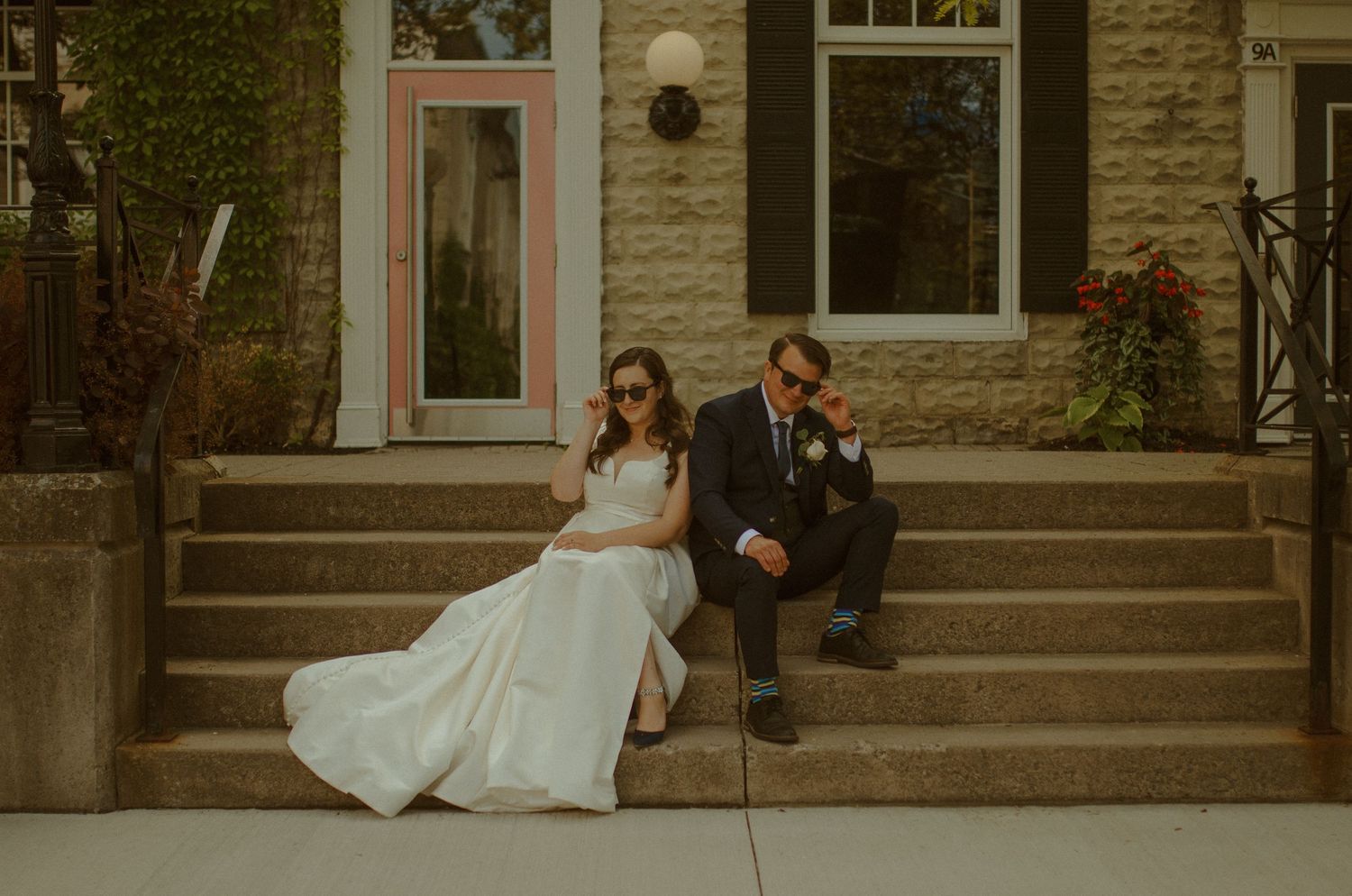 Romantic wedding couple shares an intimate moment on the steps of a historic stone building.