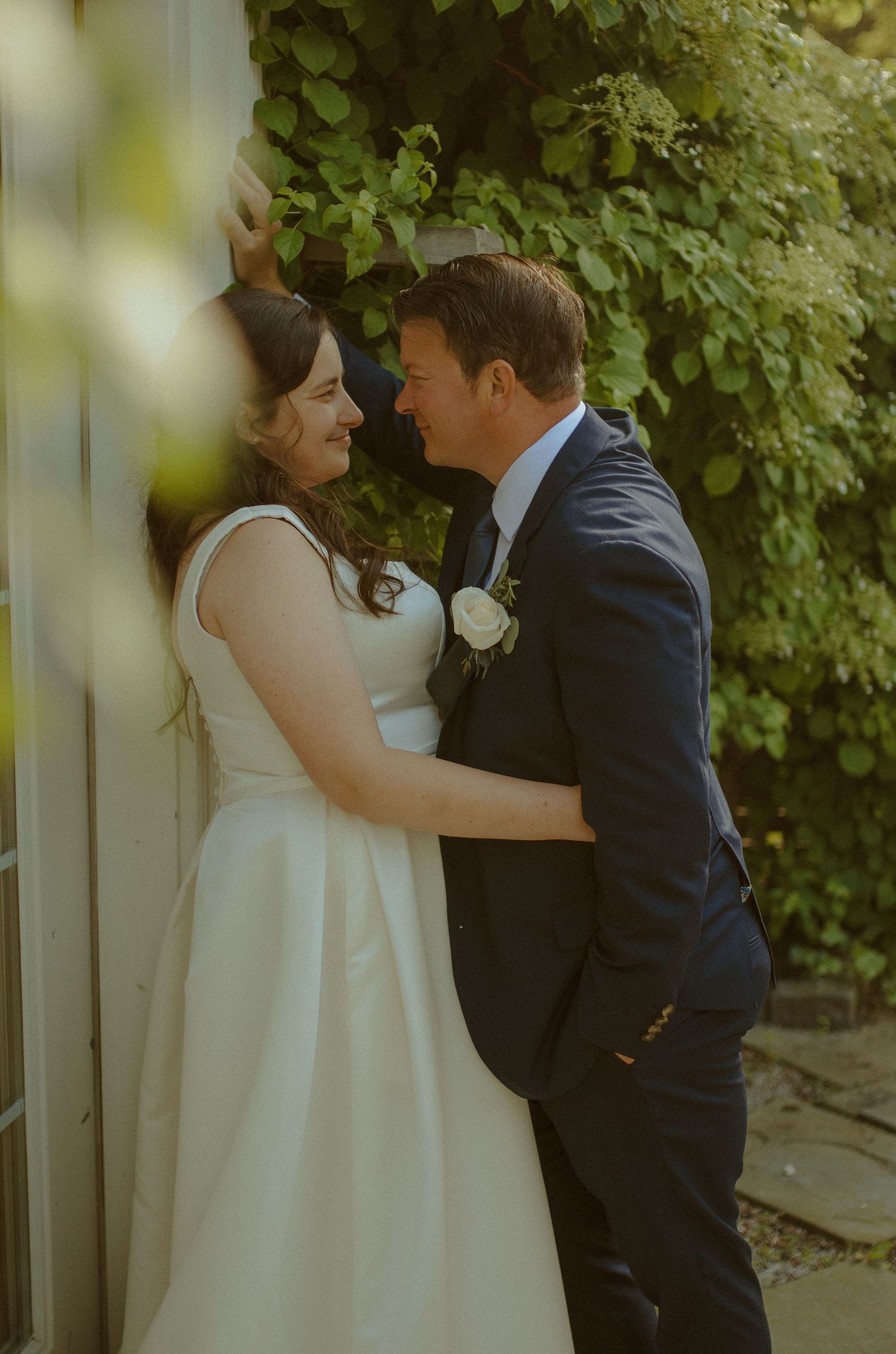A tender first look moment between the bride in white and groom in navy before their wedding ceremony.