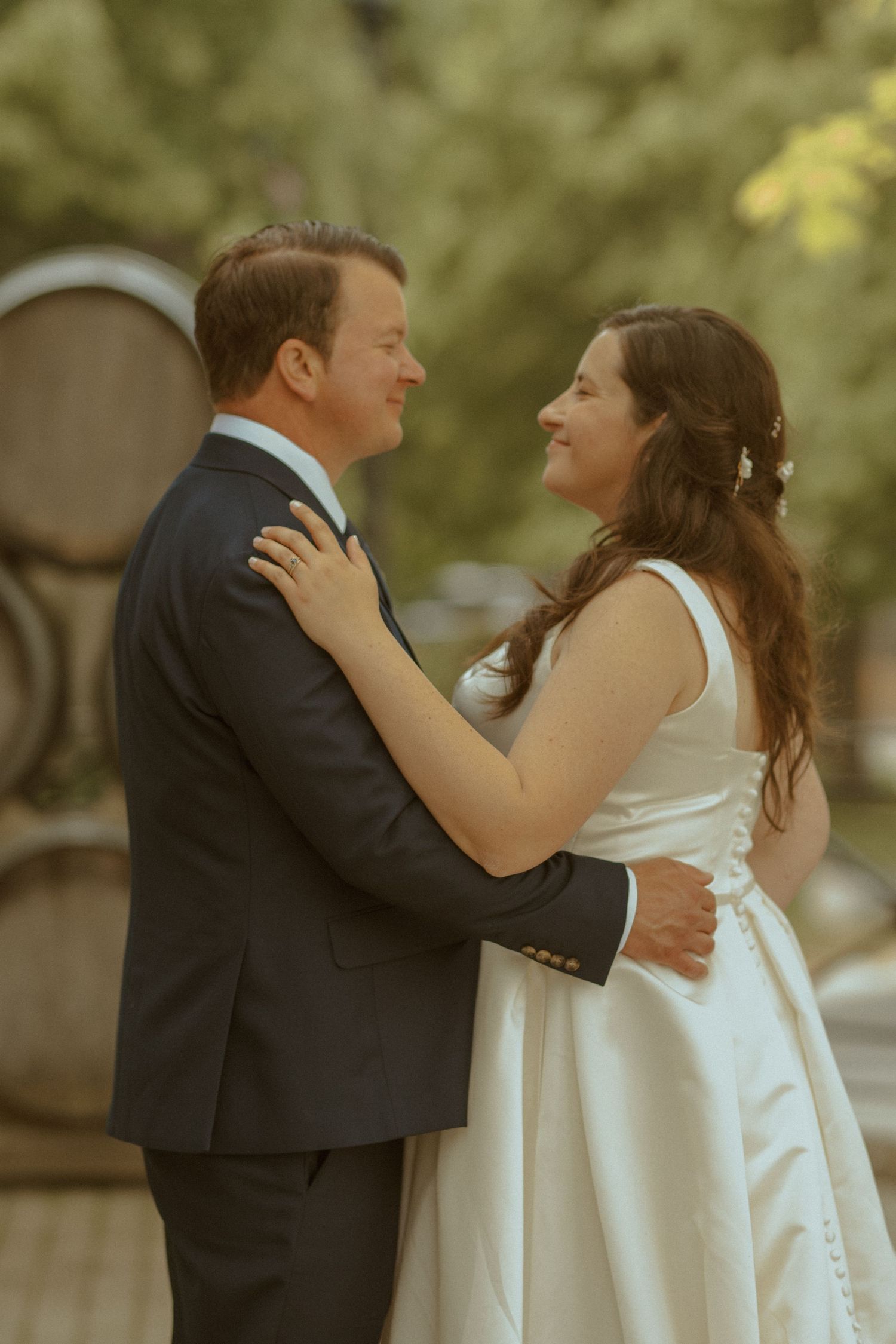 A romantic embrace between newlyweds during their outdoor wedding ceremony.