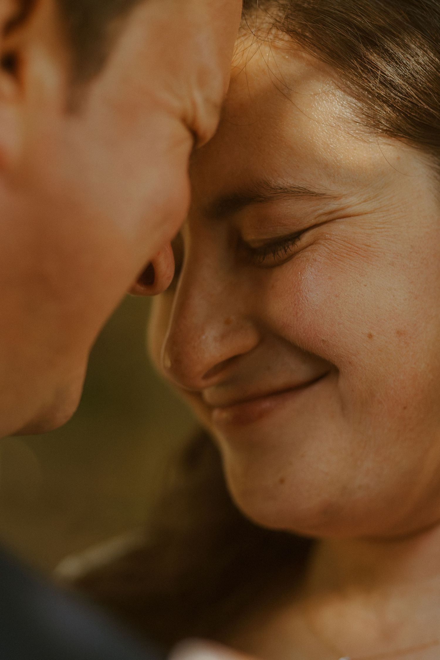Intimate warm-toned close-up of a romantic moment between two people.