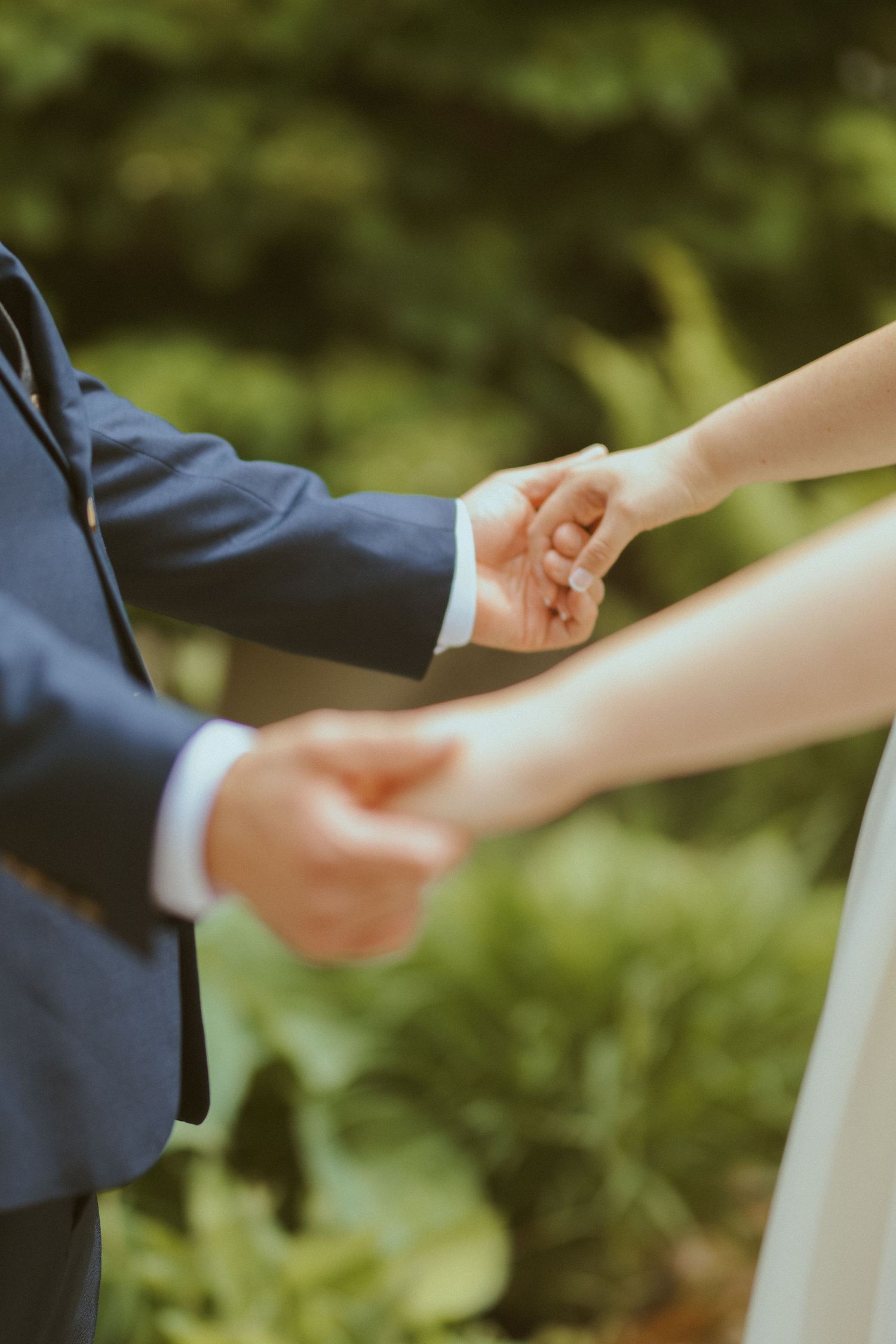 Sequential photos capturing hands reaching for each other against a green outdoor background.