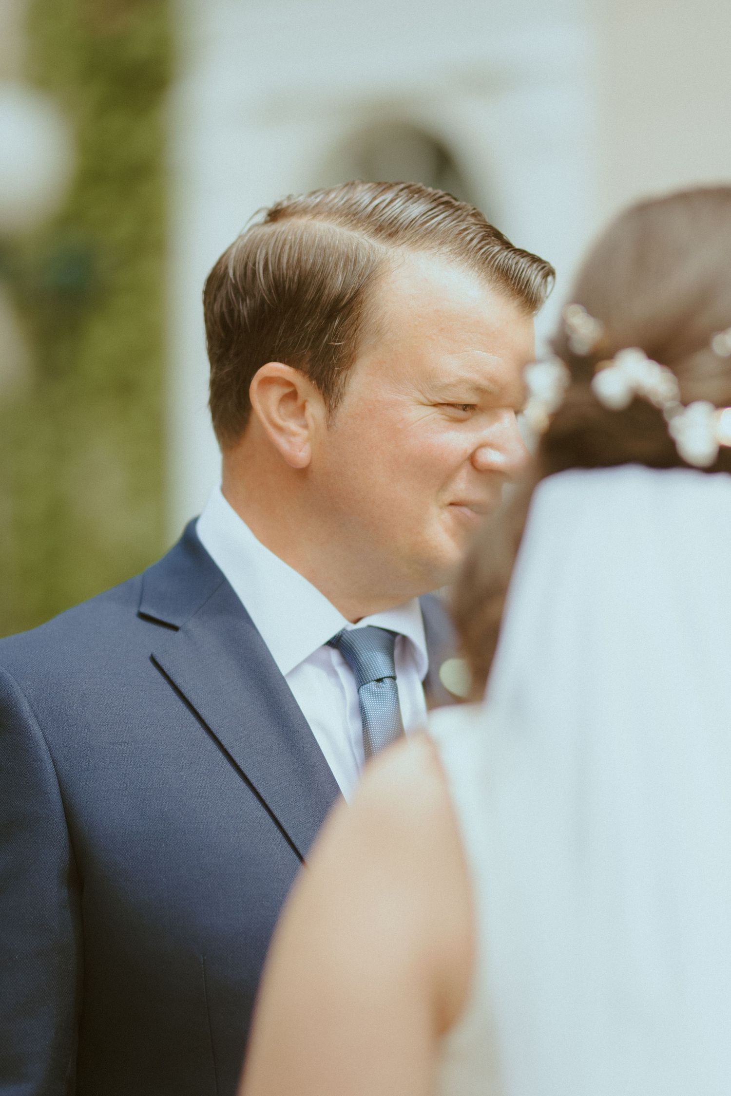 Close-up shot of wedding couple during an intimate outdoor ceremony moment.