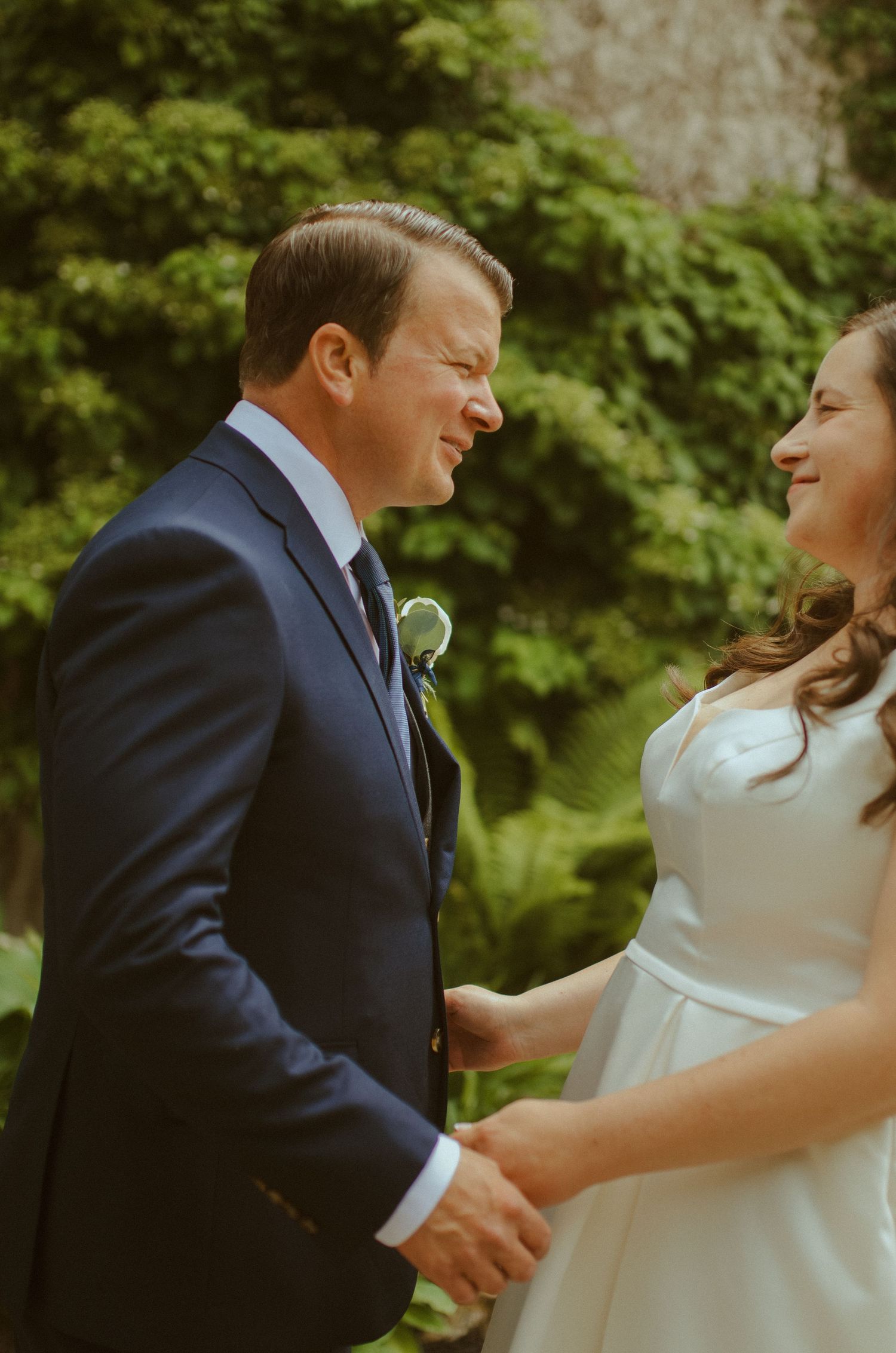 Joyful couple sharing a candid laughing moment together during their outdoor wedding portraits.