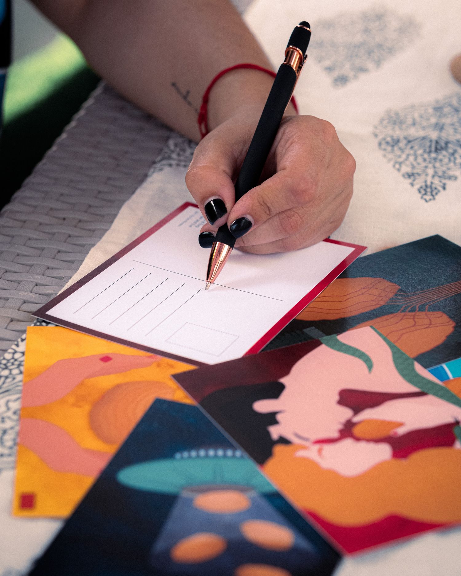 Person writing in a notebook next to illustrated romantic artwork.