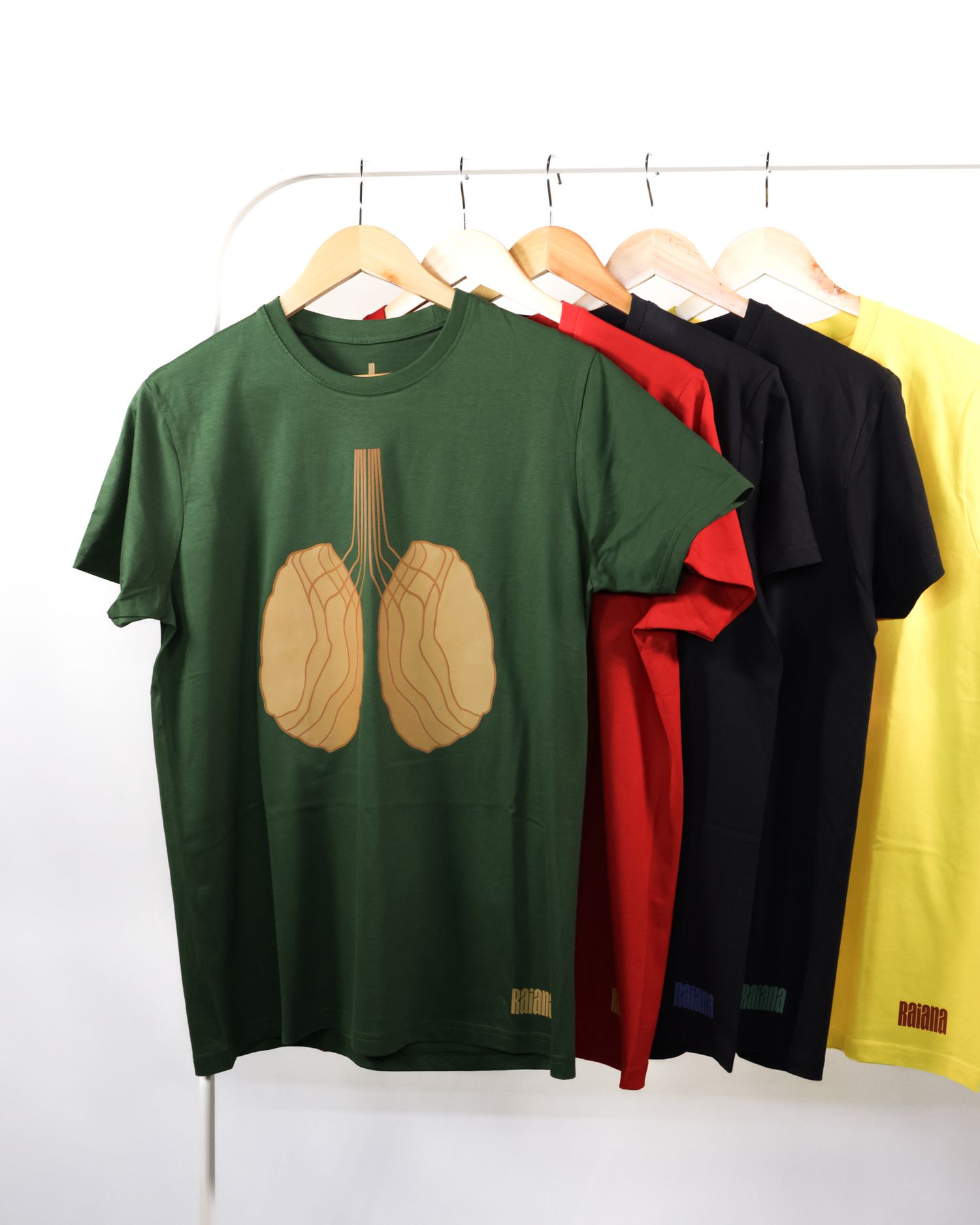 Collection of t-shirts in different colors featuring shell designs hanging on rack.