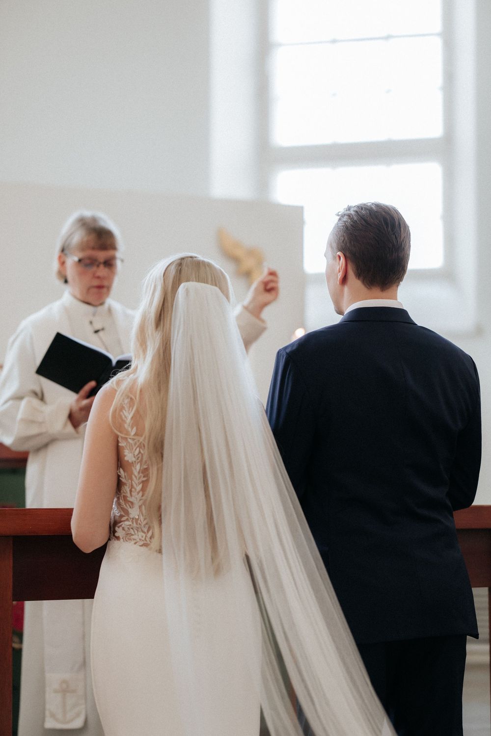A traditional church wedding ceremony in progress with the bride in white and clergy officiating at the altar.