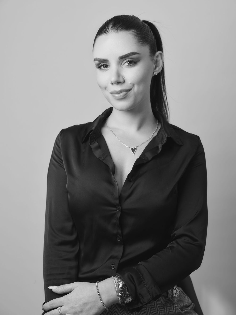 Professional black and white portrait series showing a person in a dark button-up shirt against a light backdrop.