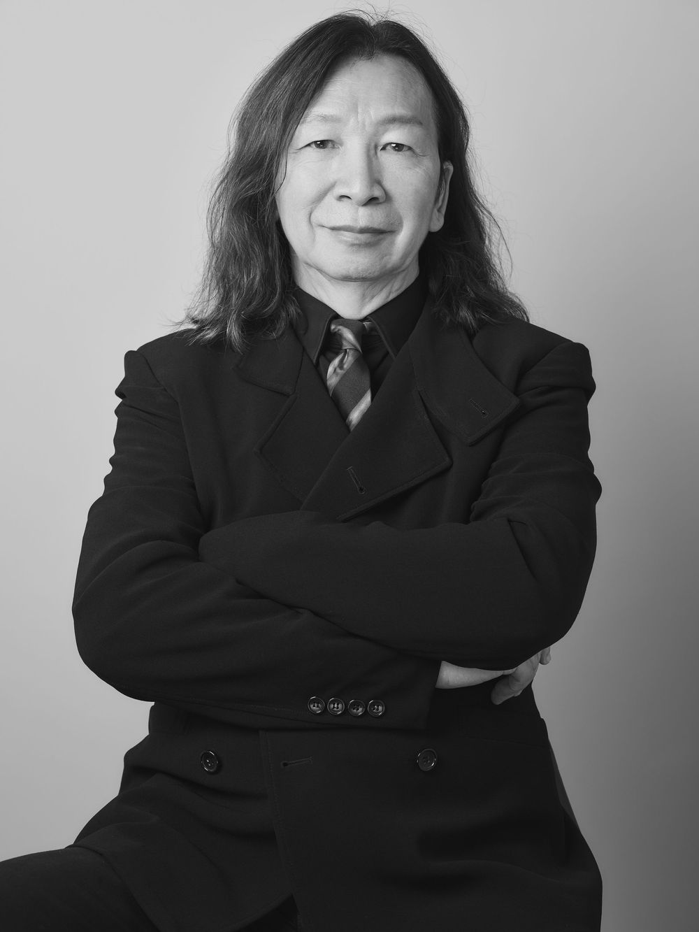 Professional headshots series with person wearing dark coat and showing different expressions.