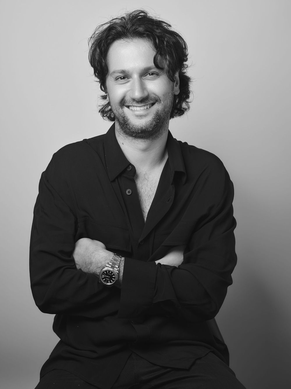 A series of black and white portraits showing someone in a dark button-down shirt with curly hair against a light background.