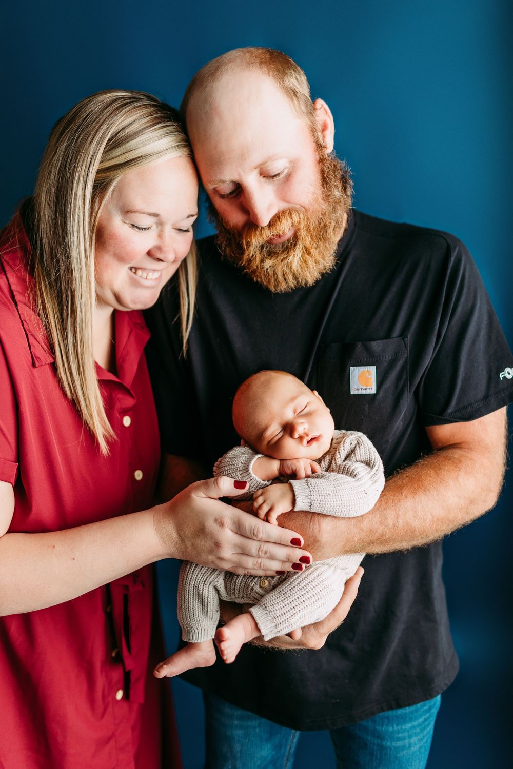 Four intimate captures of parents bonding with their newborn baby wearing a knit outfit.
