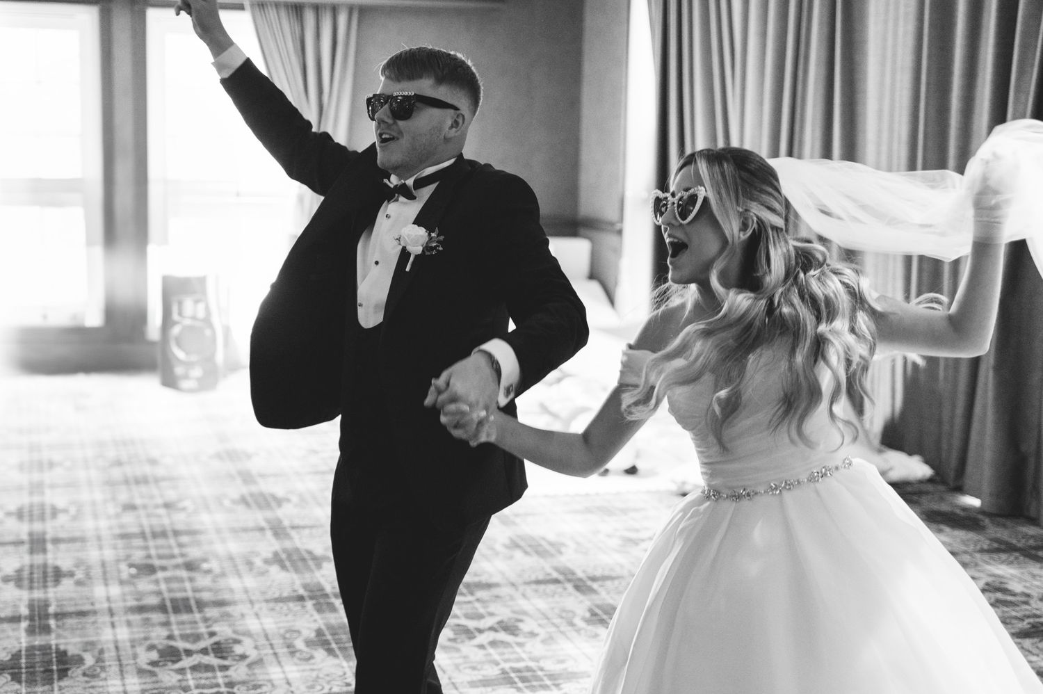 A couple dances joyfully at their wedding reception in formal attire by Scottish wedding photographer Lynsey Kay.