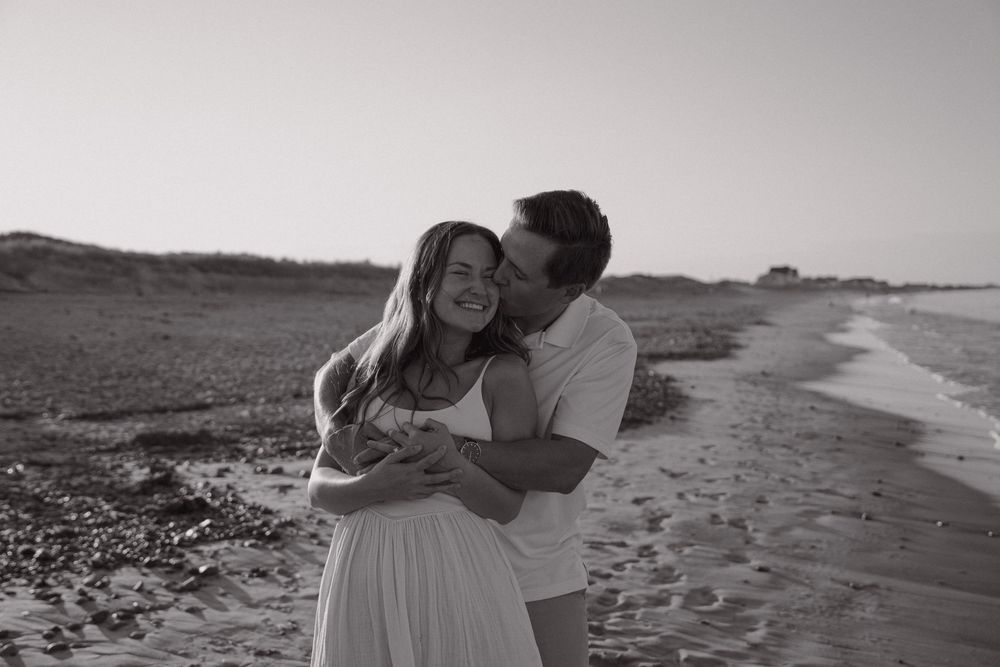 A series of romantic black and white beach photographs showing a couple embracing along the shoreline at sunset.