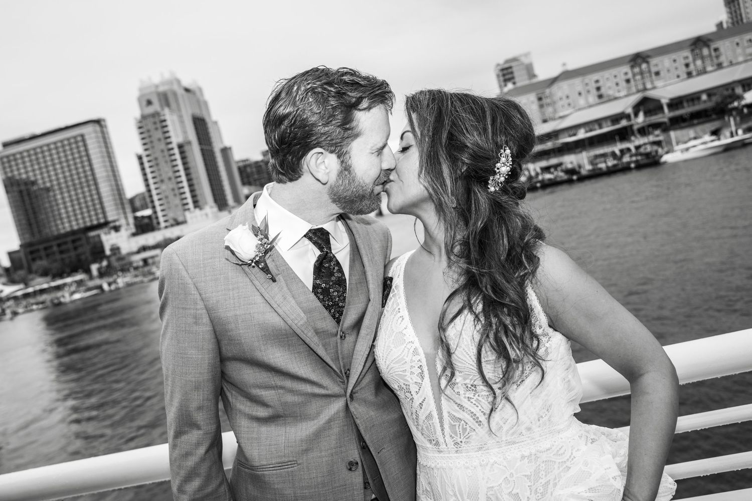 A collection of black and white wedding photographs showing romantic moments at a waterfront setting.