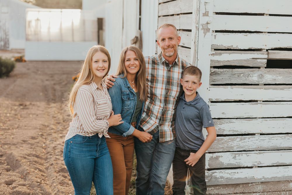 Family enjoying quality time together outdoors in a rustic setting with soft sunset lighting.