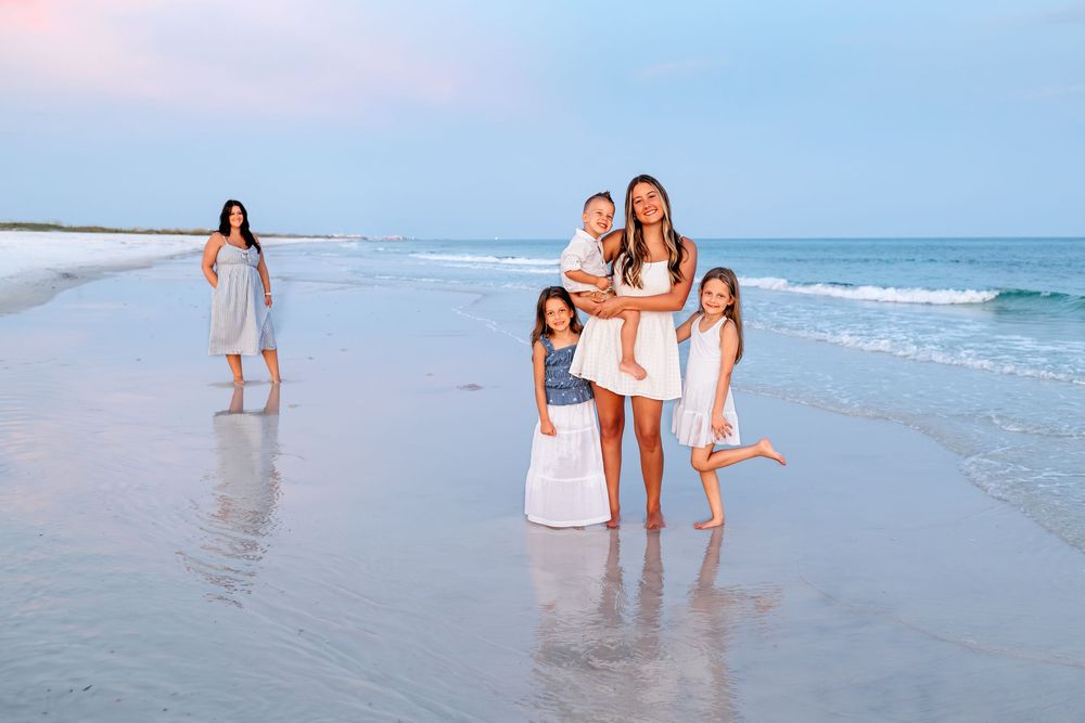 People walking along the shoreline at sunset enjoying the waves and ocean breeze on a sandy beach.
