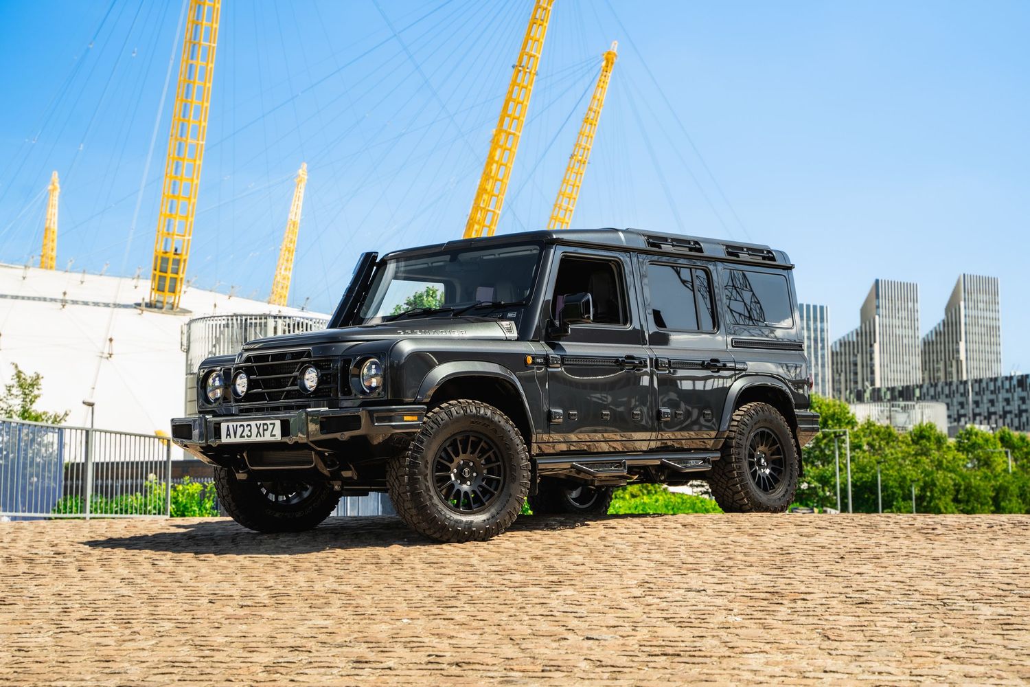 Black Mercedes G-Wagon vehicles lined up against urban skyline backdrop.
