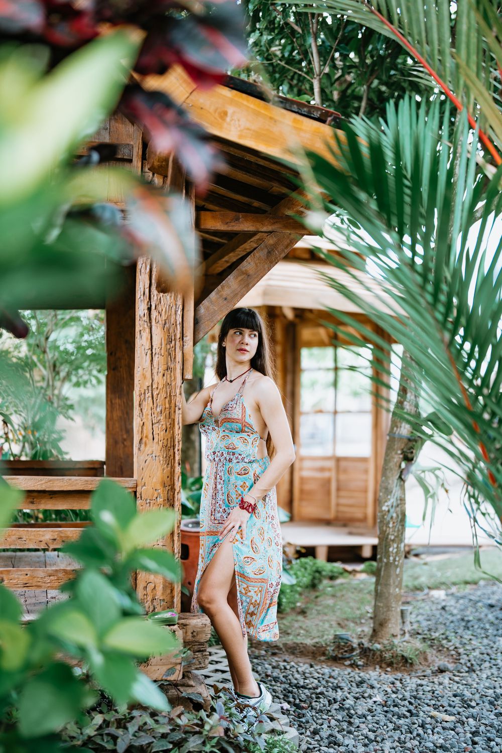 Tropical garden setting with wooden beams and palm fronds creating natural framing.