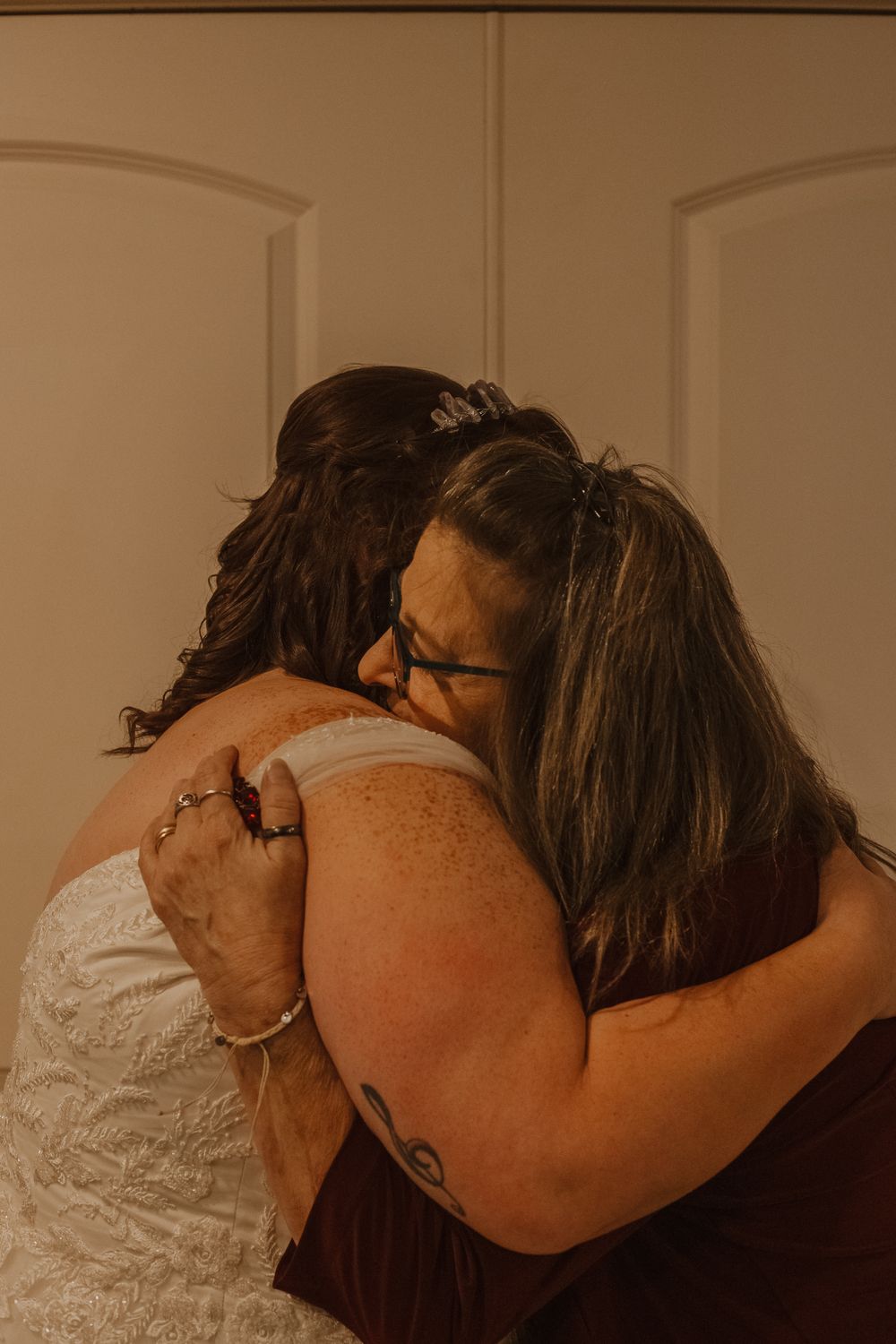 Emotional embrace captured during wedding celebration.