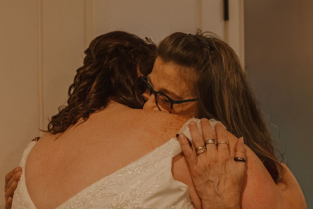 Intimate moment shared during wedding celebration in warm lighting.