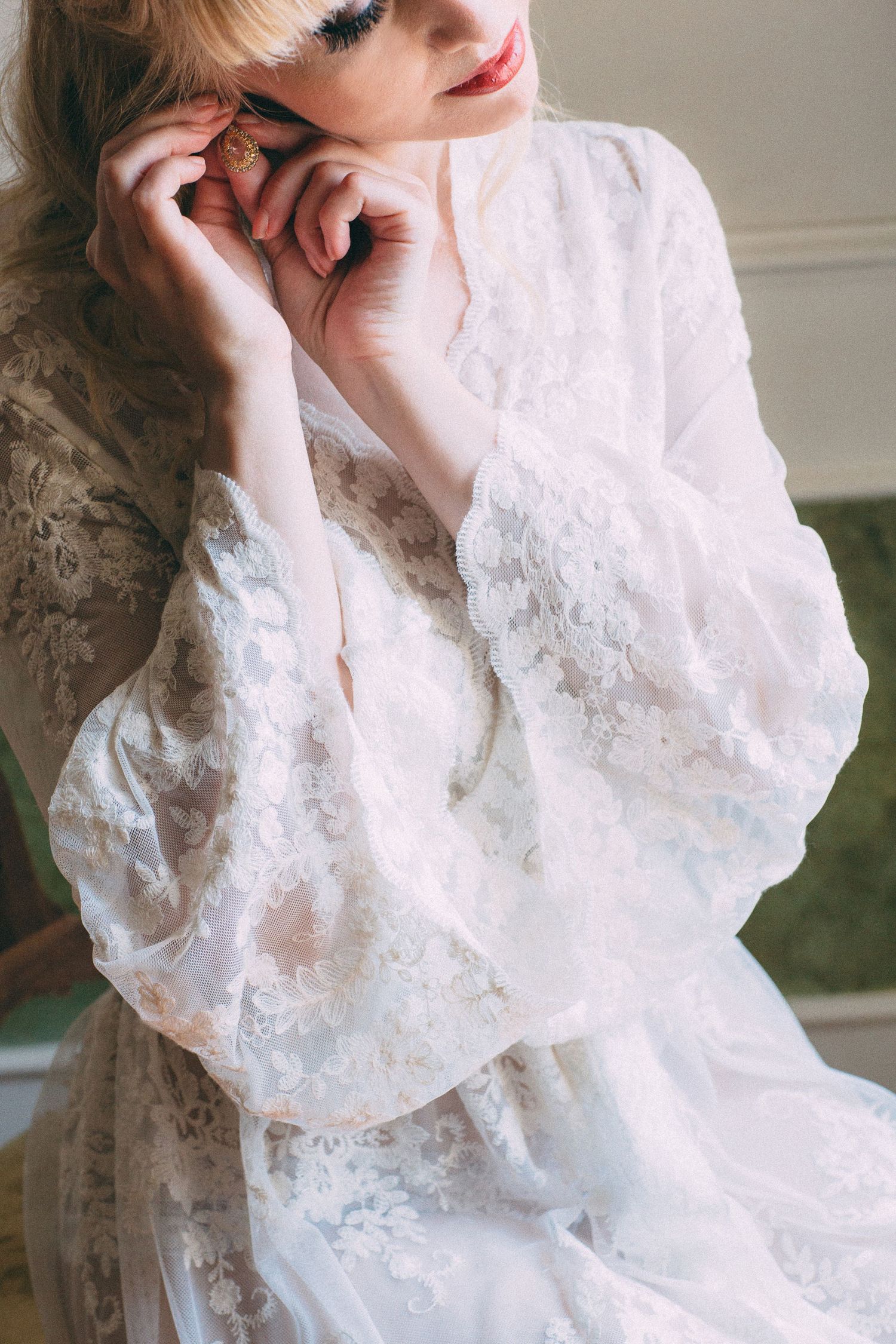 Ethereal close-up of lace wedding dress sleeve details in soft natural light.