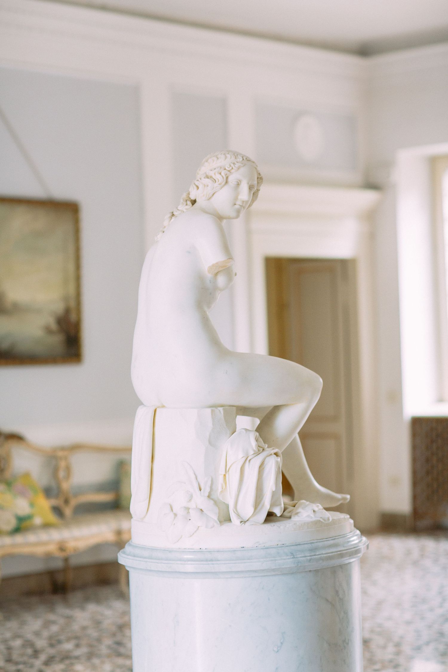 A collection of white minimalist ceramic sculptures displayed on a clean white table surface.