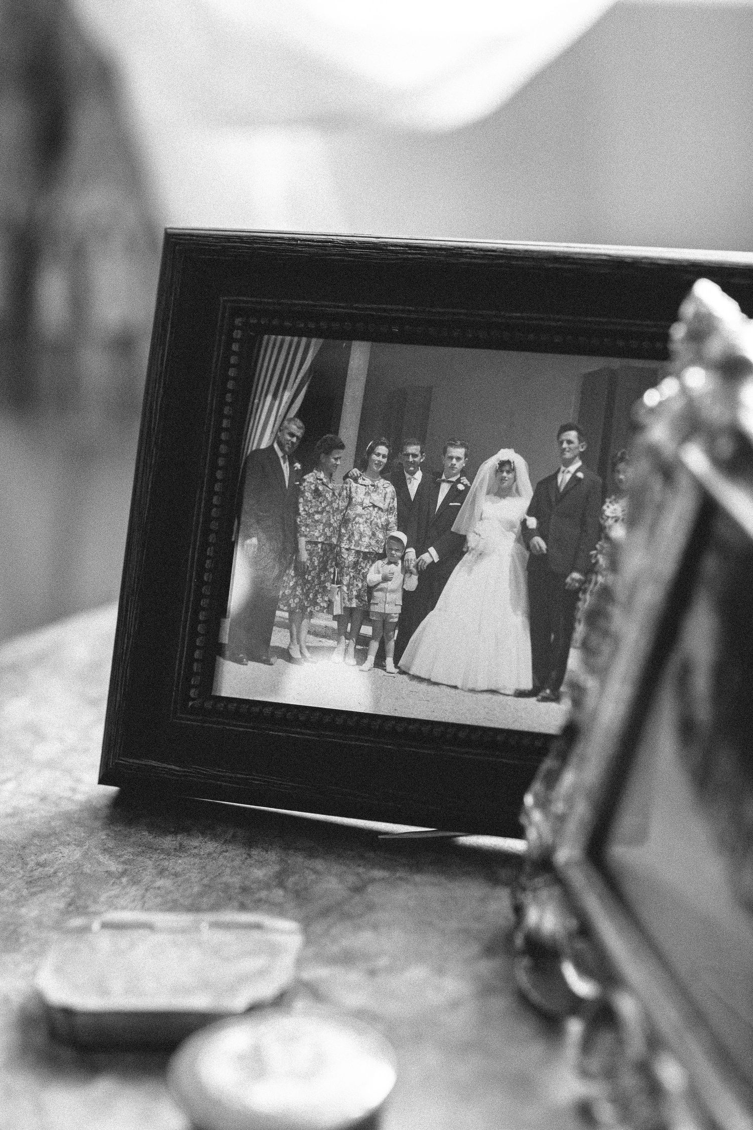 Vintage black and white wedding photographs displayed in dark picture frames.