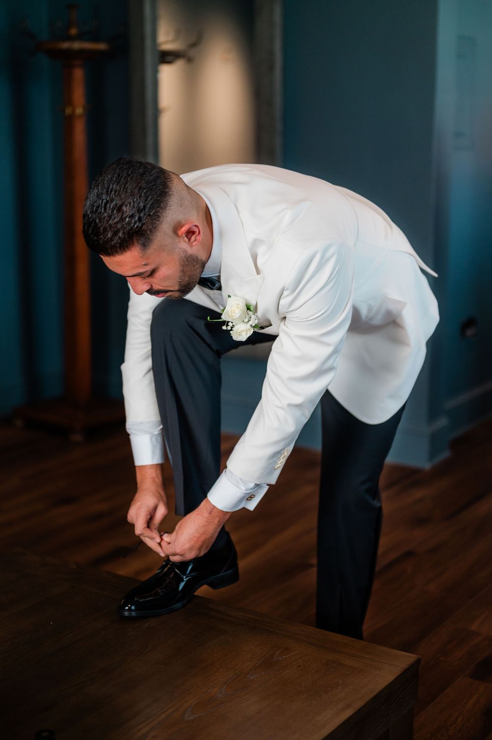 A sequence of four images showing someone in formal attire adjusting their shoe while standing on hardwood flooring.